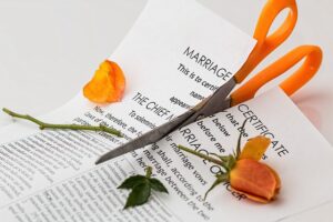 Photo of Marriage Certificate being cut in half indicating an end to a marriage and a division of assets